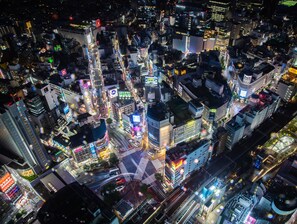 A densely packed urban area with high-rise buildings, illuminated signs, and busy streets at night. - APA Hotel Shibuya Ekimae (Tokyo)