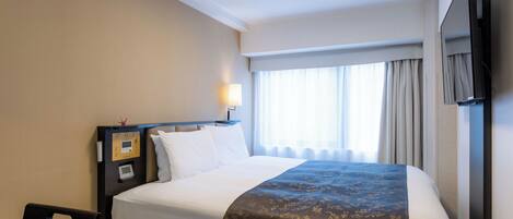 A hotel room with a bed, a bedside table, a TV, and a window with curtains.