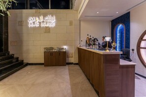 A reception area with a counter, a wall-mounted sign, and a decorative wall feature.
