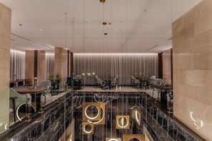 A modern hotel lobby with a marble reception desk, seating area, and a glass partition. - Lilac Park Neom Highway Hotel Ex Lilac Park Hotel (Tabuk)
