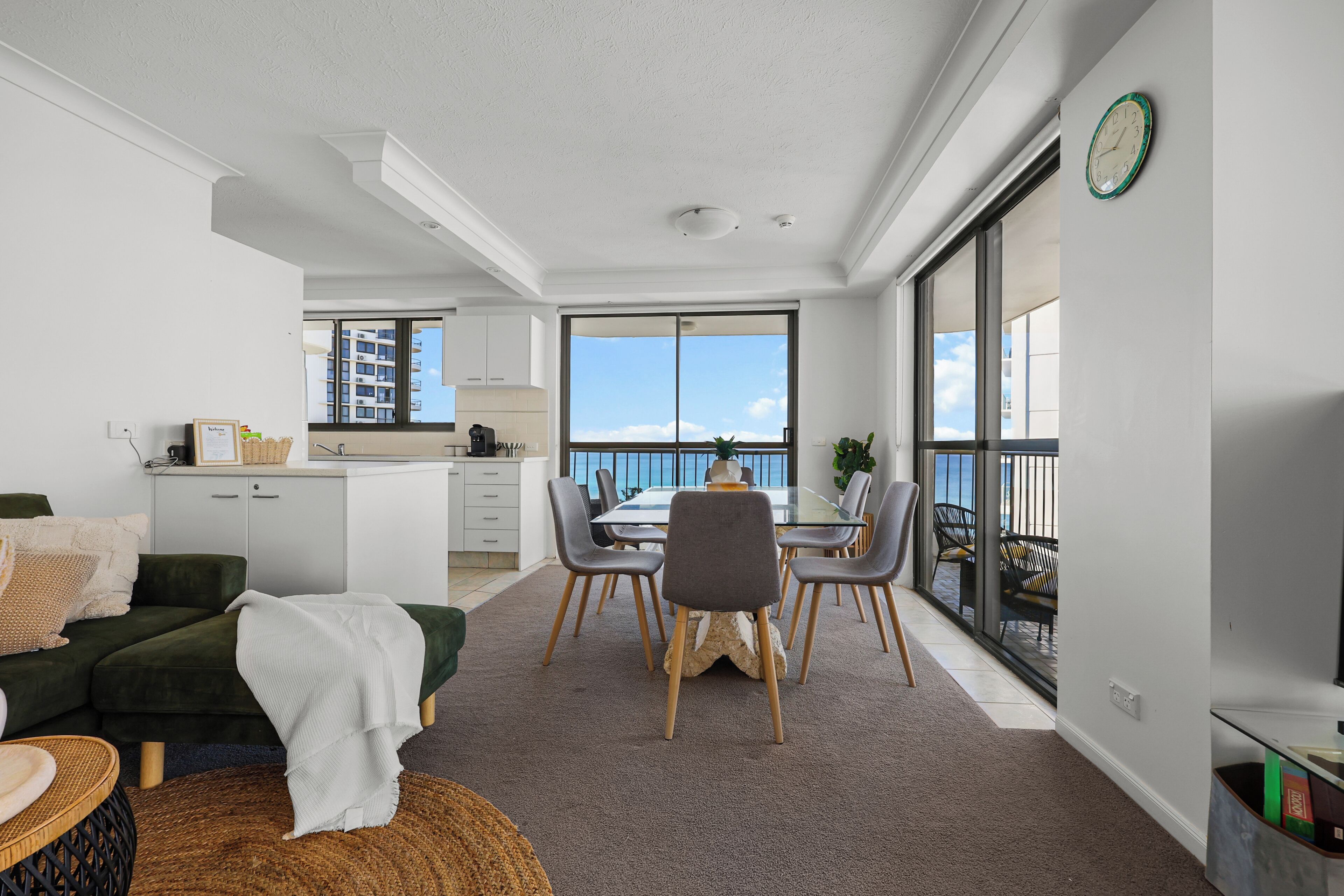 A modern apartment with a dining area, kitchen, and a balcony with a view.