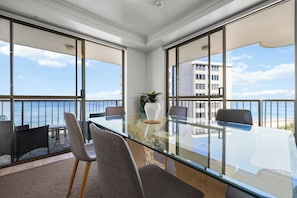 Une salle de conférence moderne avec une table en verre, des chaises et une plante en pot.