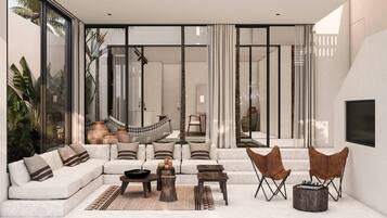 Una sala de estar moderna con sofá, mesa de centro y sillas, ventanas amplias y vista a una escalera.