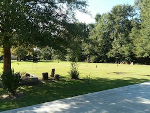 Un parque con sendero adoquinado, árboles y una zona verde.