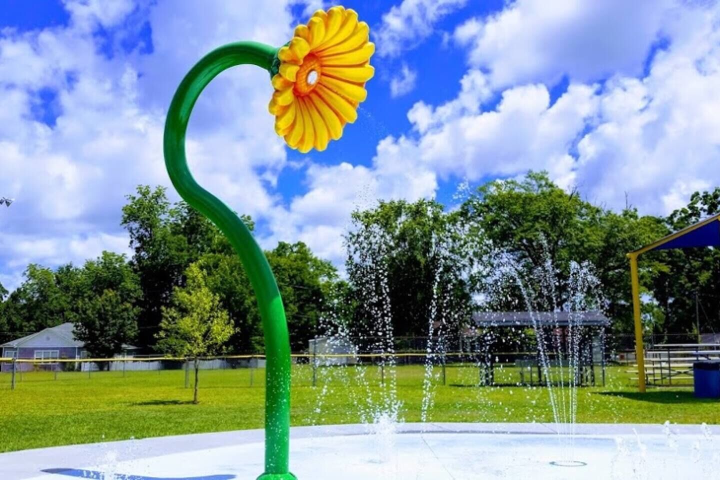 Una fuente con una estructura verde y un objeto similar a una flor amarilla.