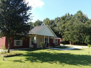 A single-story house with a front porch, a brick exterior, and a lawn. - The "Home Over the Bridge" (Atmore)