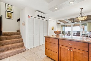 A kitchen with a wooden cabinet, a built-in oven, and a staircase leading to a closet.