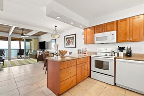 A modern kitchen with wooden cabinets, a white stove, and a microwave.