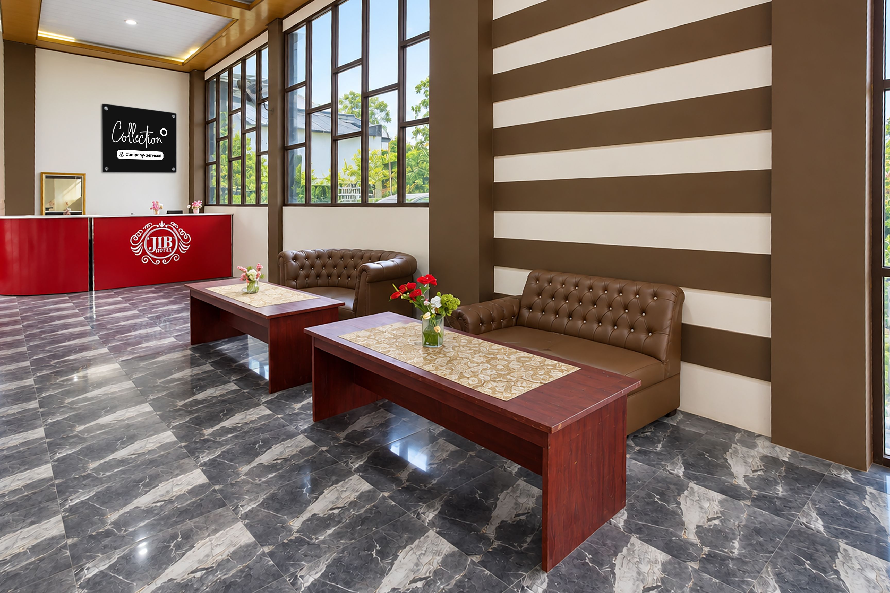 Un hall de hotel con una recepción, una zona de estar con un sofá y una mesa, y un amplio ventanal con vistas al exterior.