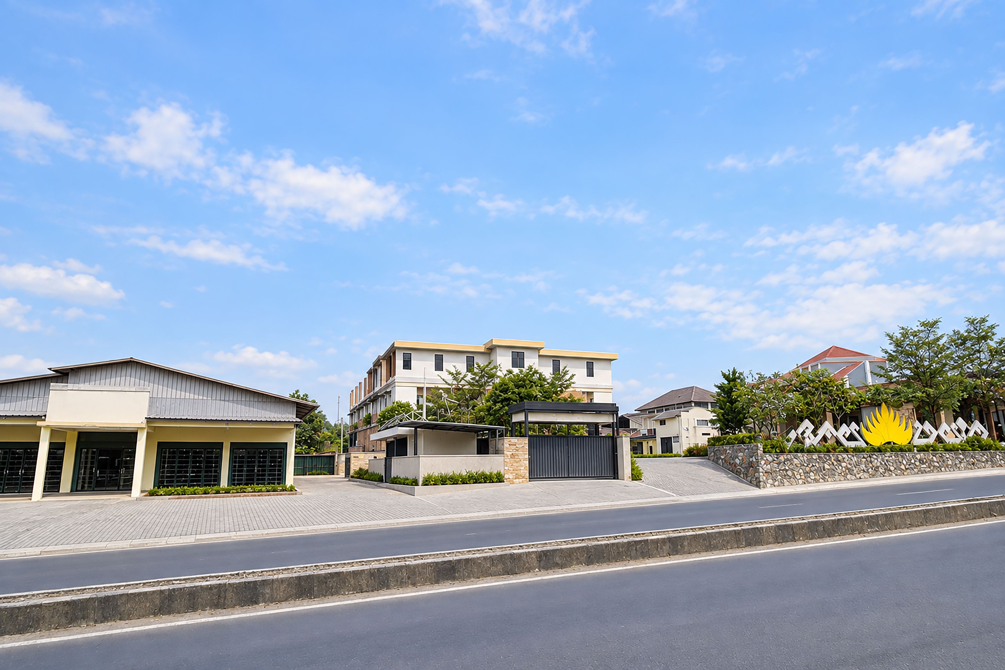 A modern residential area with a multi-story building, a covered walkway, and a gated entrance.