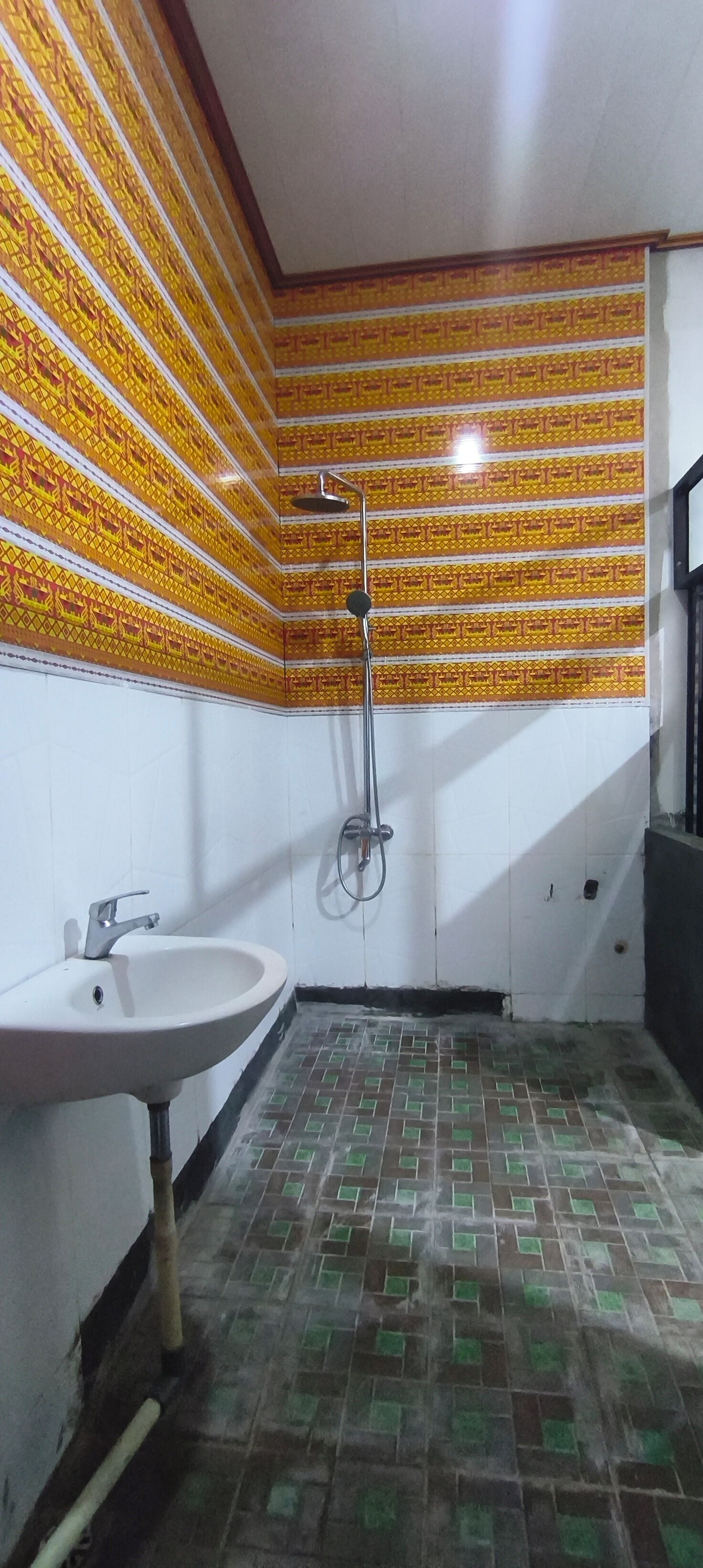 Un baño con lavamanos, ducha y paredes con diseño.