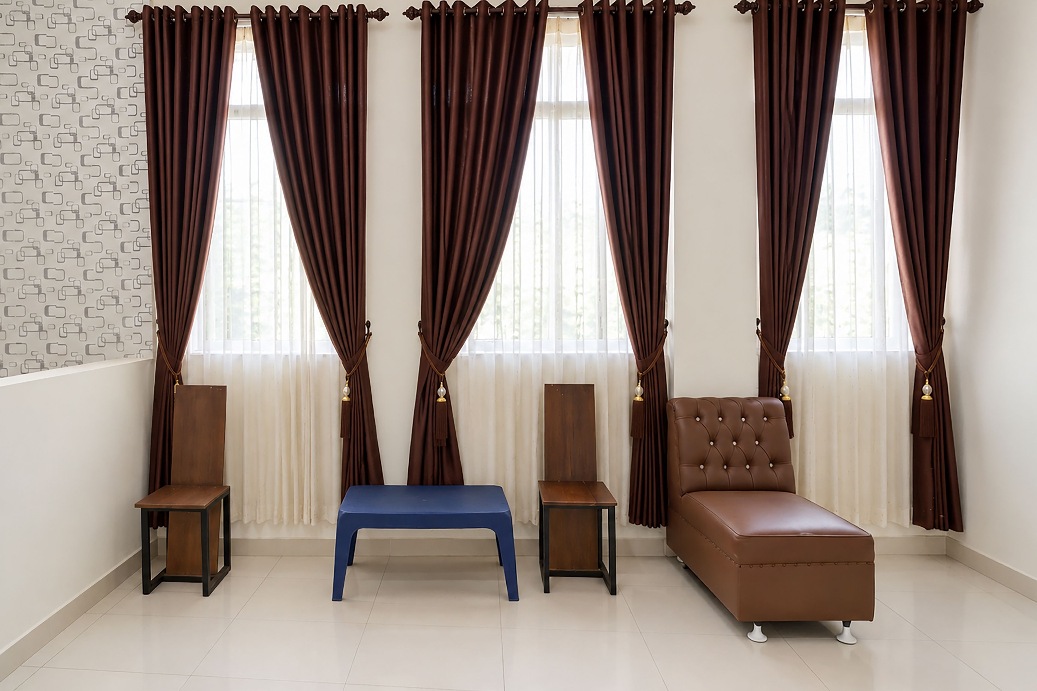 A room with a brown sofa, a blue bench, and two small tables.