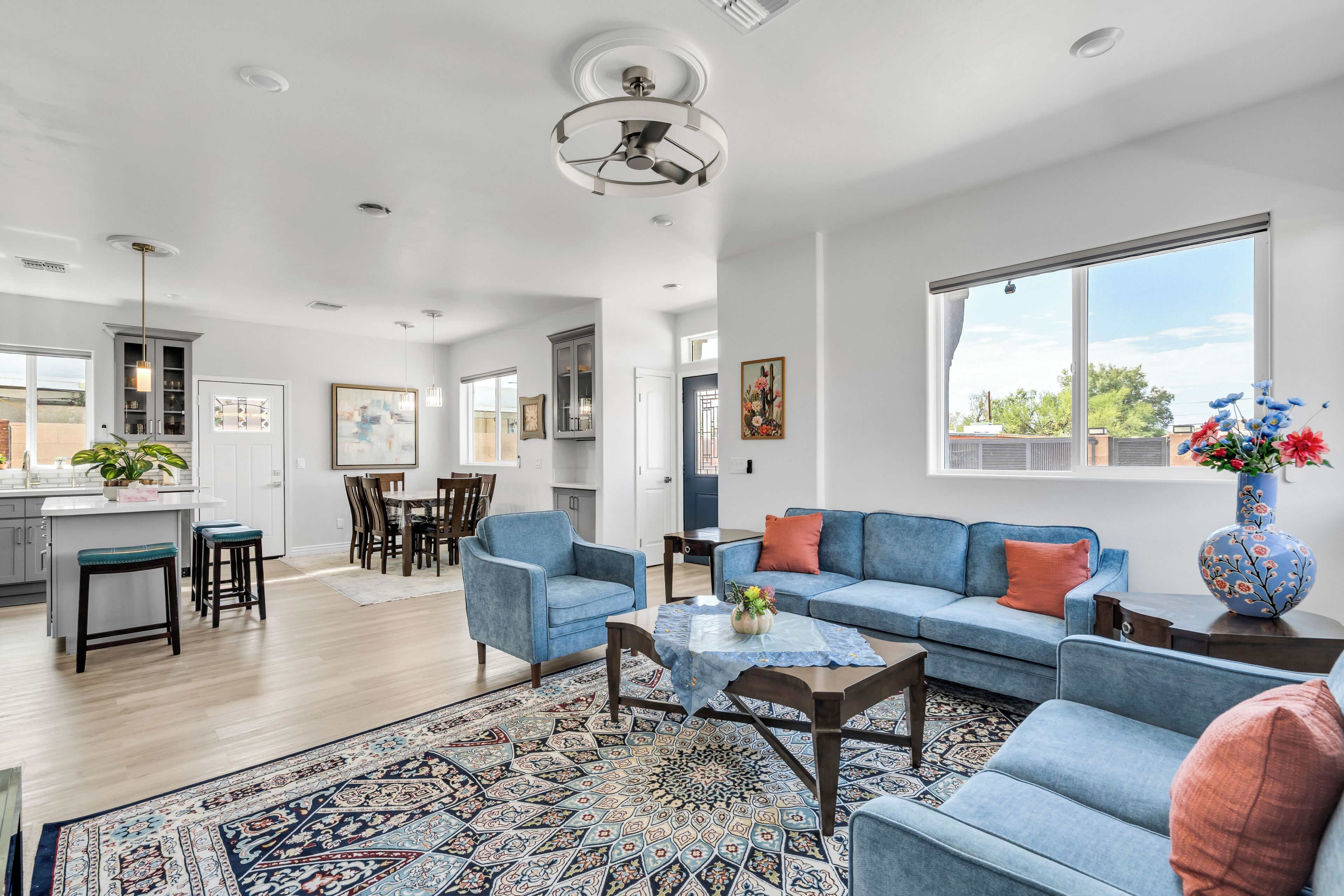A spacious living area with a blue sofa, a coffee table, and a patterned rug.