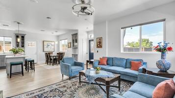 A spacious living area with a blue sofa, a coffee table, and a patterned rug.