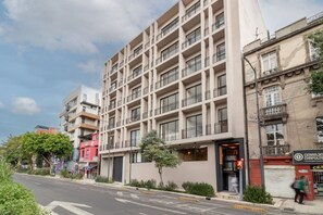 Ein mehrstöckiges Hotel mit moderner Fassade, Balkonen und einem Eingang im Erdgeschoss.