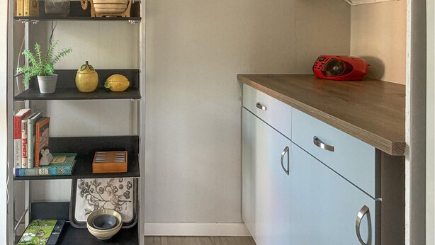 A kitchen with a wooden countertop, a red speaker, and shelves with books and kitchenware. - 3 bedroom gorgeous home in Hemse (Hemse)