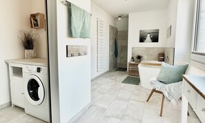 Ein modernes Badezimmer mit Badewanne, Duschbereich und Toilette.