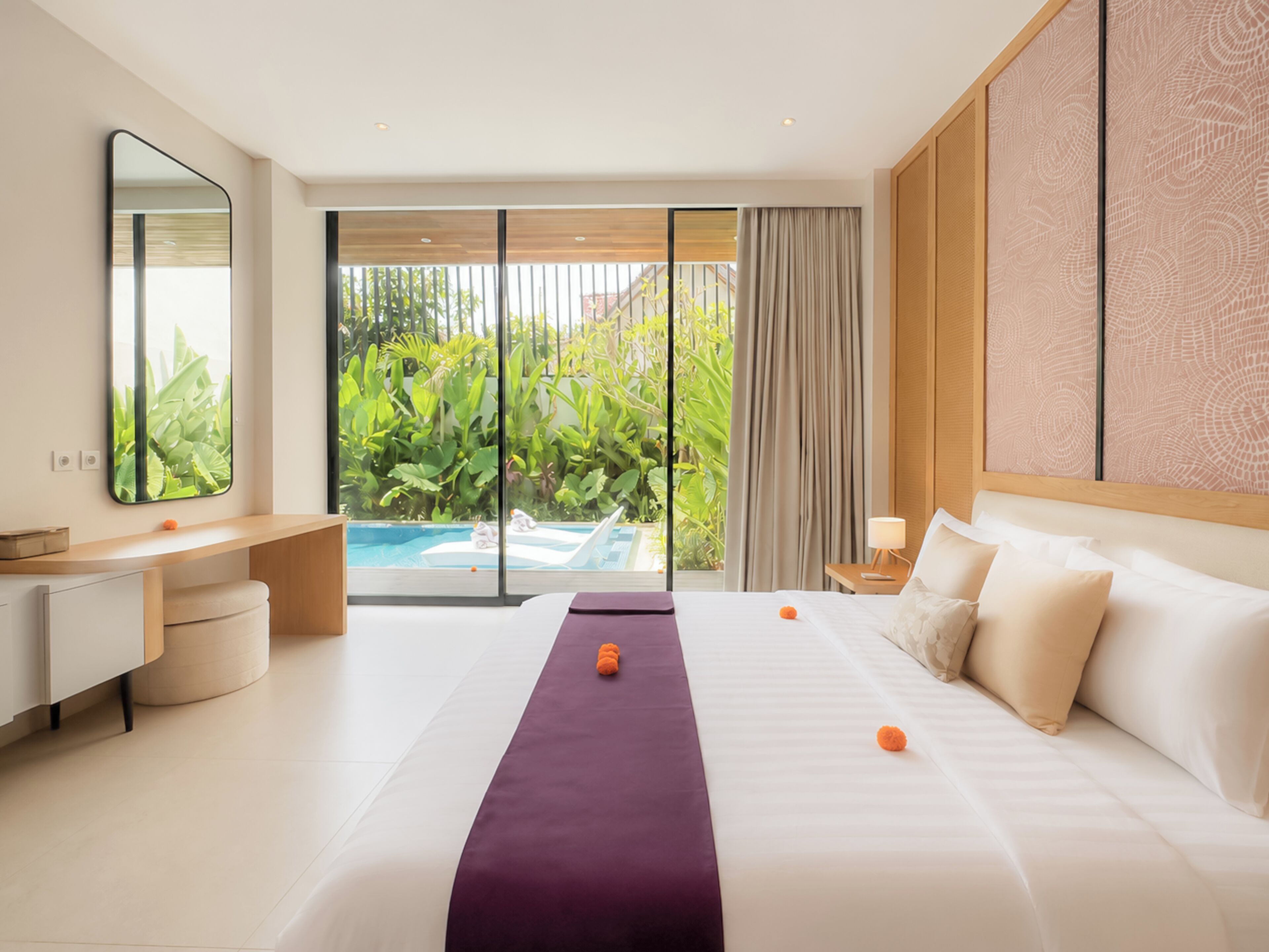Habitación de hotel con cama, escritorio, silla, ventana con vista a follaje y piscina.