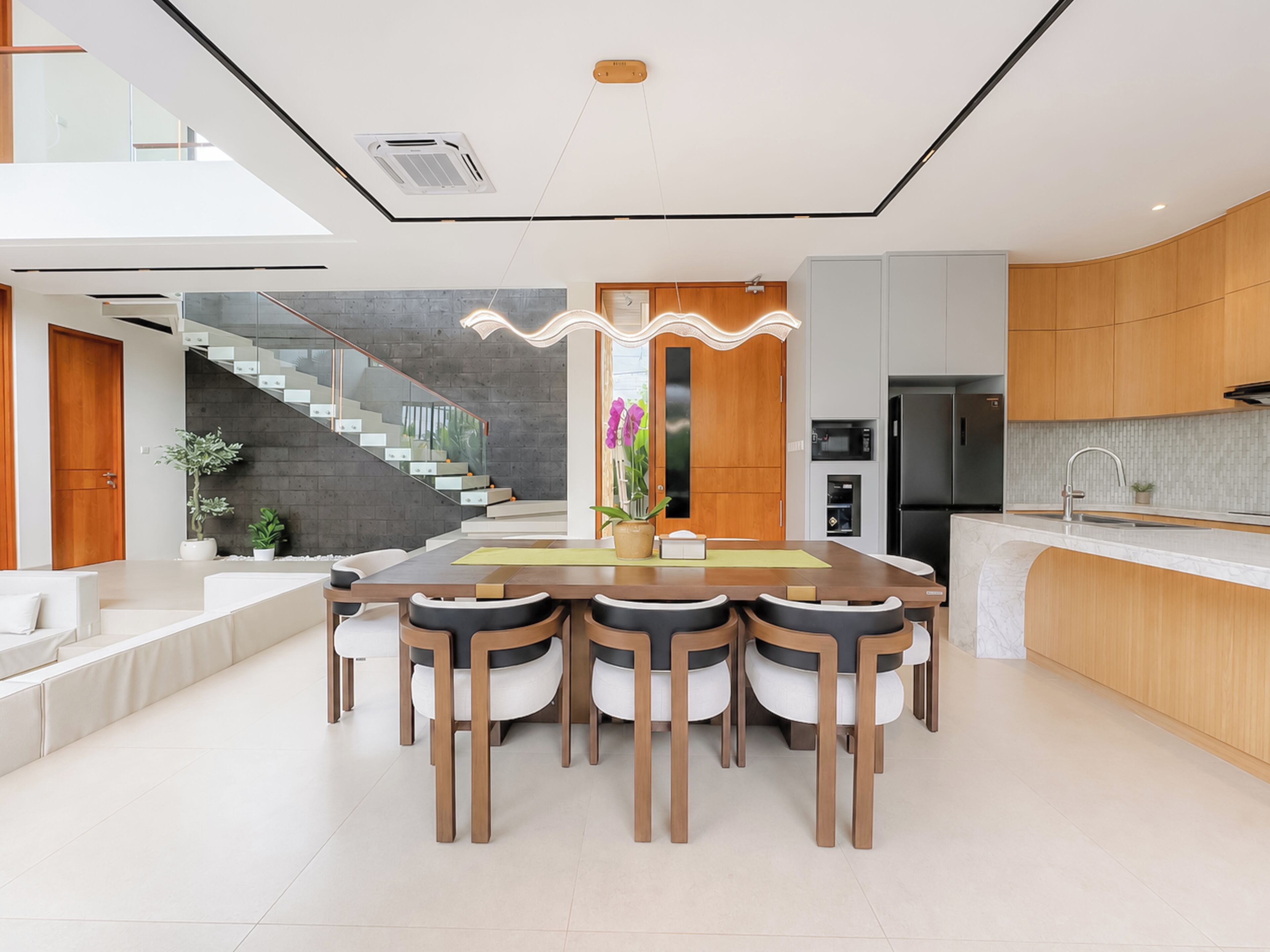 Een moderne keuken met een centraal eiland, houten kastjes en een ingebouwde oven.