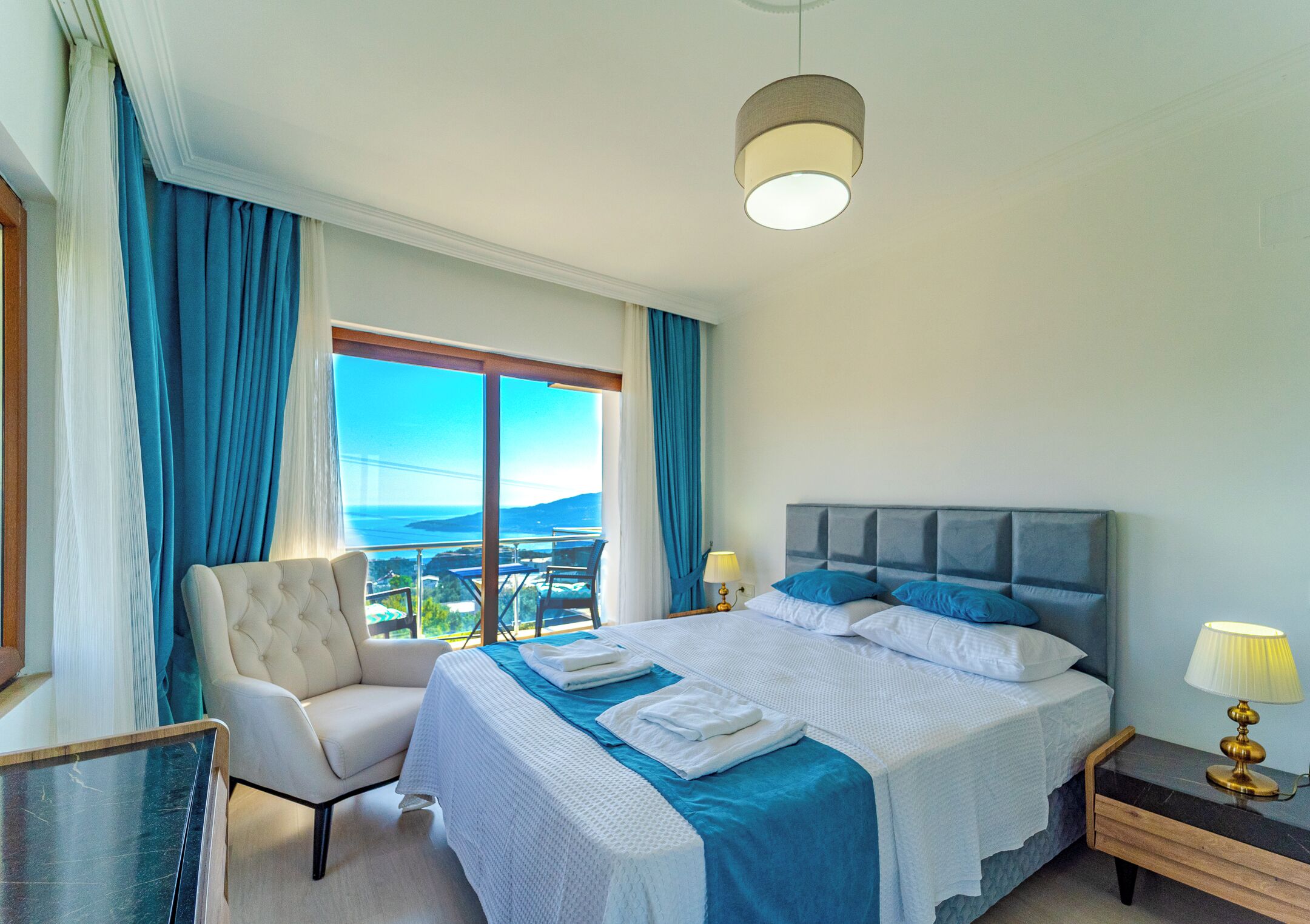 Une chambre d’hôtel avec un lit, une chaise, une table de chevet et une vue sur l’extérieur.