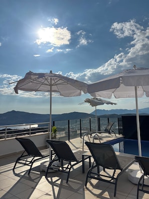 A rooftop terrace with outdoor seating and a pool, overlooking a mountainous landscape. - Superb 3-bedroom house with AC in charming Kaş (Kaş)
