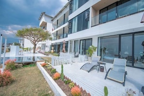 A modern hotel with a pool area, outdoor seating, and a well-maintained garden. - View of the Sea Vatican (Dali City)