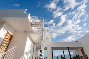 A modern building with a white exterior, a spiral staircase, and a view of the sky. - View of the Sea Vatican (Dali City)