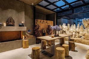 A modern interior with a fireplace, wooden stools, and a glass ceiling. - View of the Sea Vatican (Dali City)