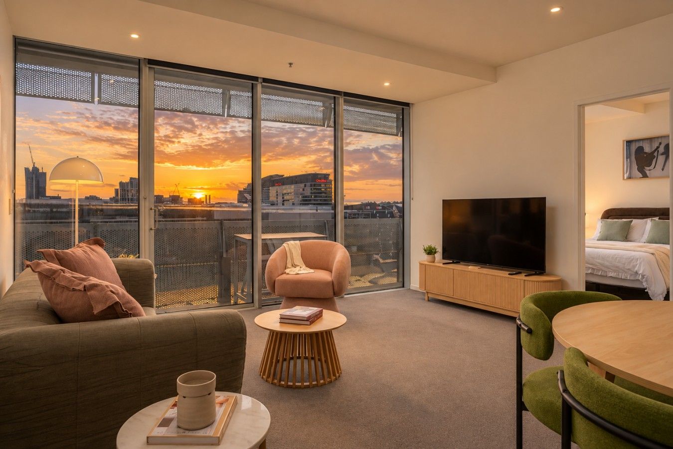 Un salon moderne avec un canapé, un fauteuil, une table basse et un téléviseur.