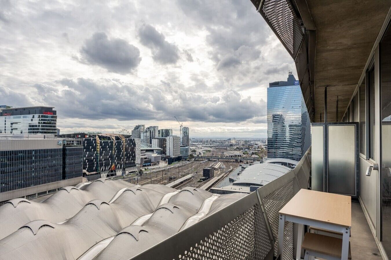 Ein Hochhaus mit modernem Design, ausgestattet mit einem Balkon, der einen Tisch und Stühle bietet.