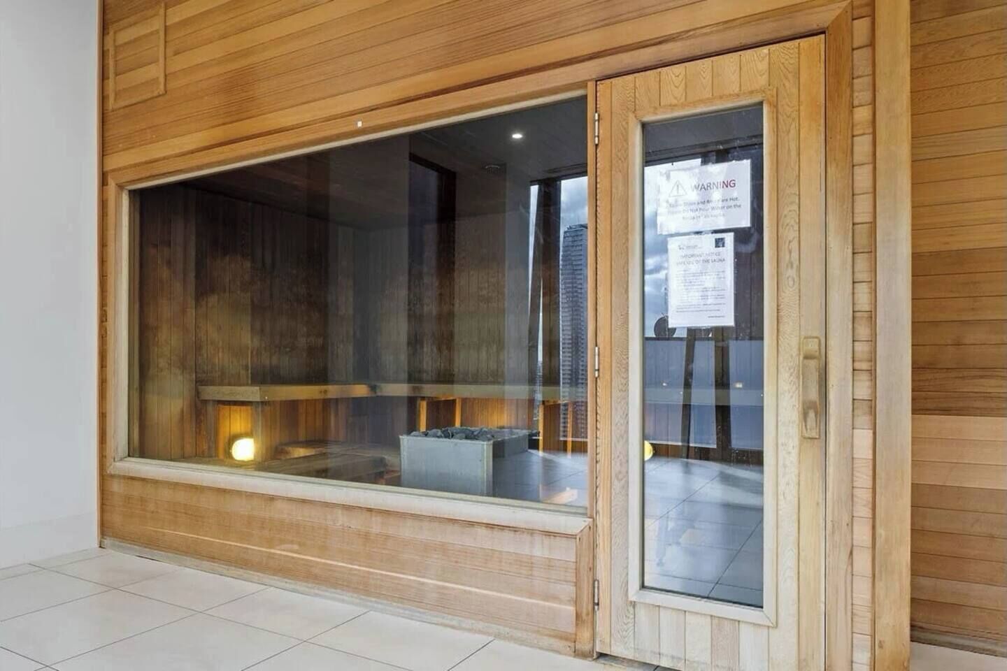 A room with a large window, wooden paneling, and a tiled floor.