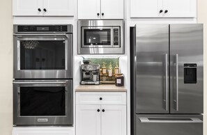 A kitchen with stainless steel appliances including an oven, microwave, and refrigerator. - Family Tides 30A Seagrove | Pool | Sleeps 16 (Santa Rosa Beach)