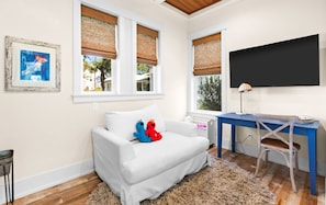 A room with a white sofa, two Elmo plush toys, a desk with a chair, a television, and a framed picture on the wall. - Family Tides 30A Seagrove | Pool | Sleeps 16 (Santa Rosa Beach)