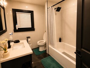 A bathroom with a toilet, sink, and bathtub.