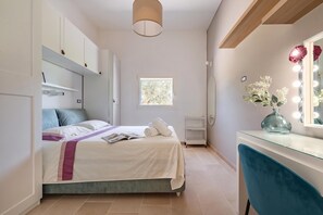 A bedroom with a bed, a vanity with a mirror, and a window. - Villa Fedali With Pool (Francavilla Fontana)