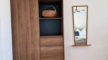 Ein Holzschrank mit Spiegel und Korb.