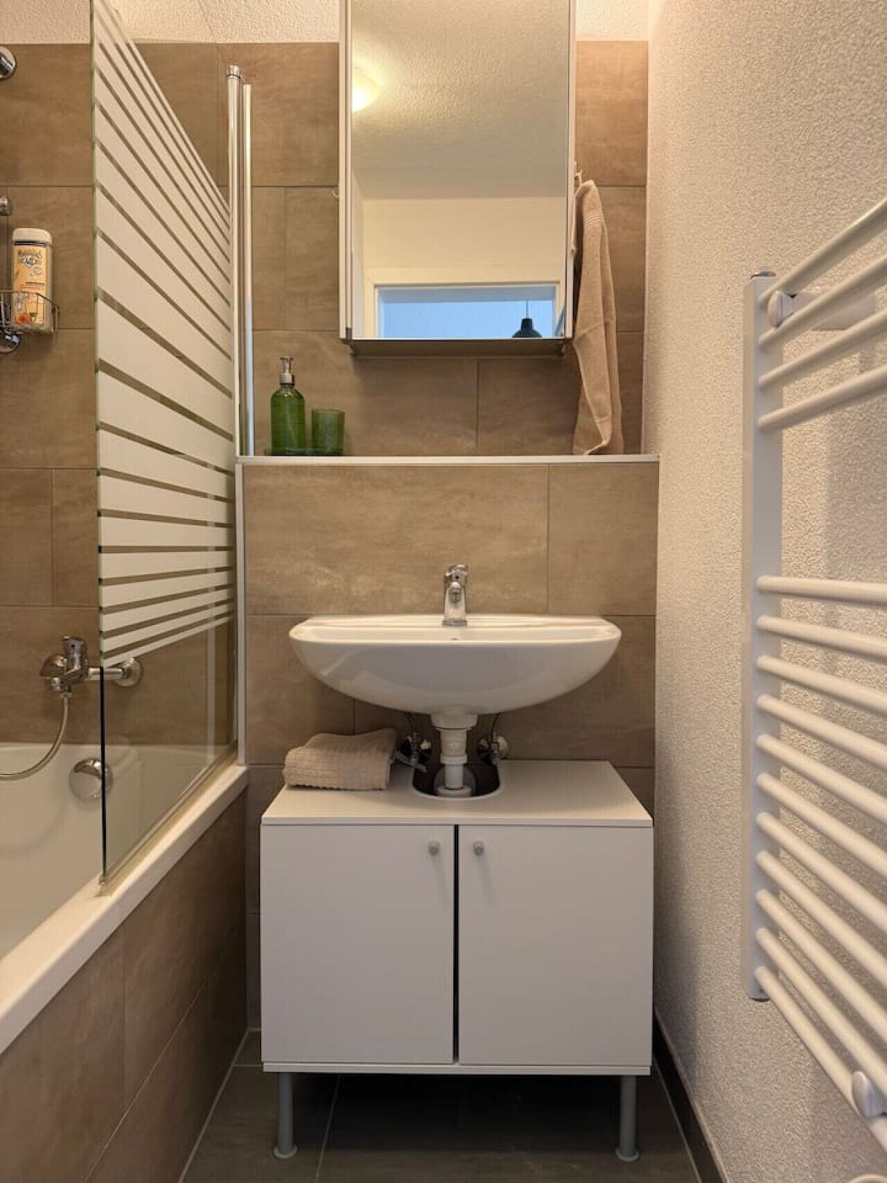 Une salle de bain avec une baignoire, un lavabo et un miroir.