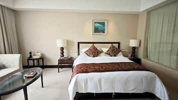 A hotel room with a large bed, two bedside tables, a chair, and a window.