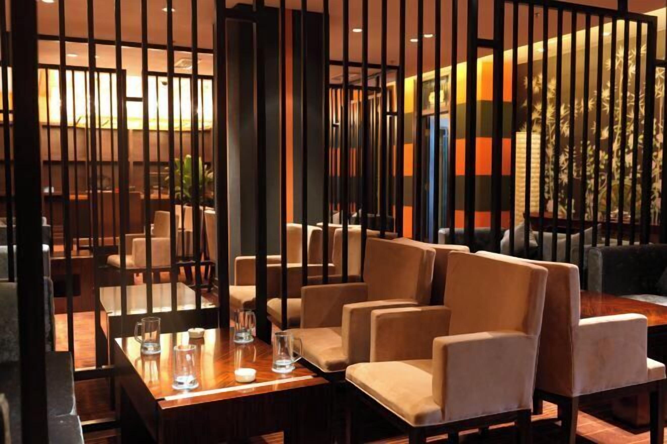 A dining area with a wooden table, beige chairs, and a decorative partition.