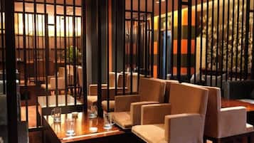 A dining area with a wooden table, beige chairs, and a decorative partition.
