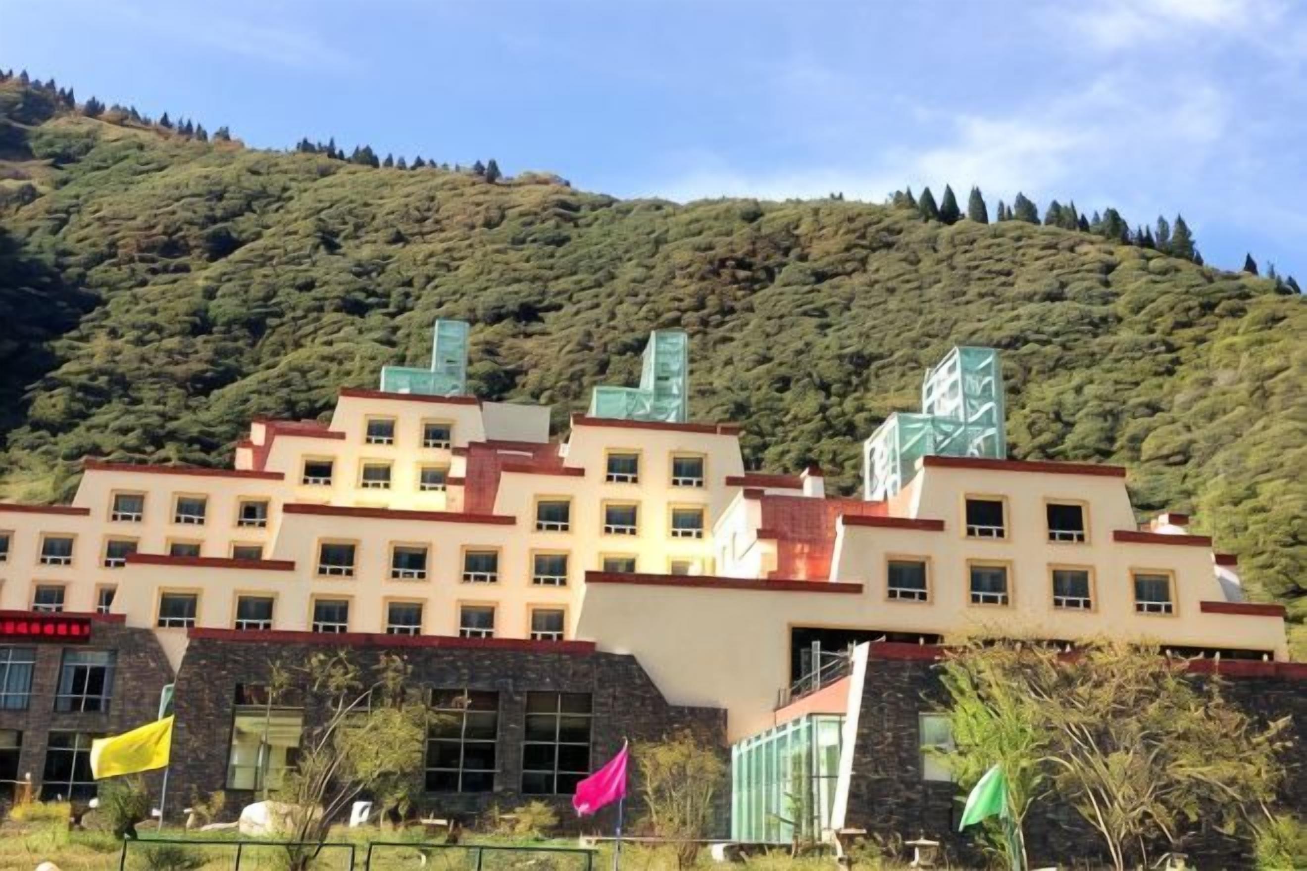 A multi-story building with a flat roof and a series of windows.