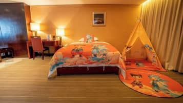 A hotel room with a bed, a desk, a chair, a lamp, and a tent-like structure.