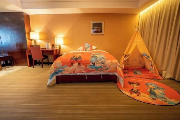 A hotel room with a bed, a desk, a chair, a lamp, and a tent-like structure.