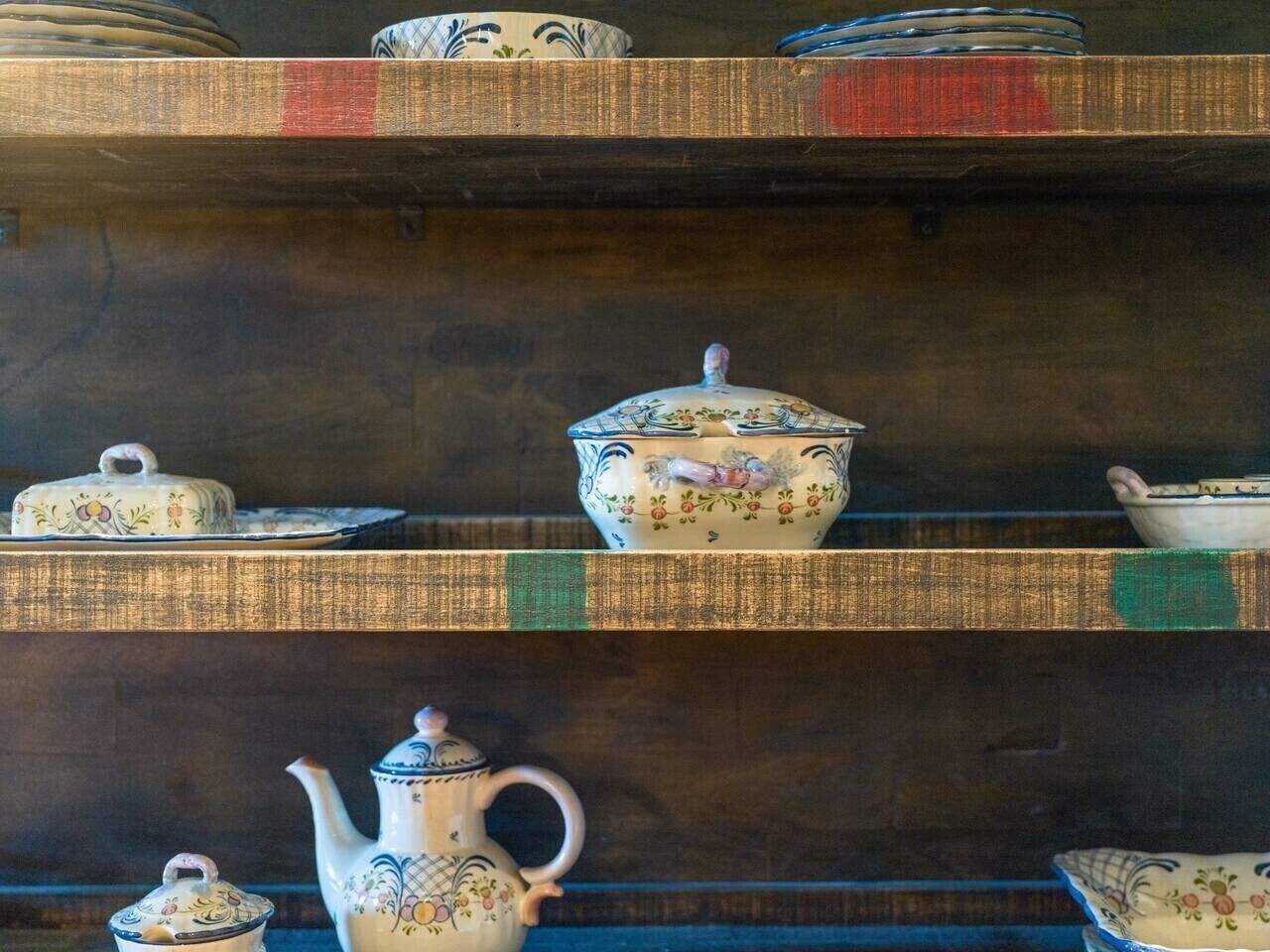 A display of ceramic tea sets on shelves.