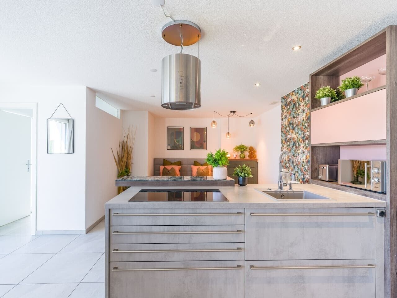 Una cucina moderna con isola centrale, elettrodomestici integrati e una decorativa parete di fondo.