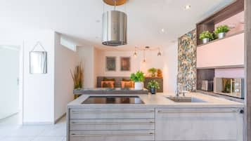 Una cucina moderna con isola centrale, elettrodomestici integrati e una decorativa parete di fondo.