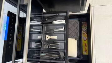 Un cajón de cocina con utensilios y envases de Jet-Cut congelados.