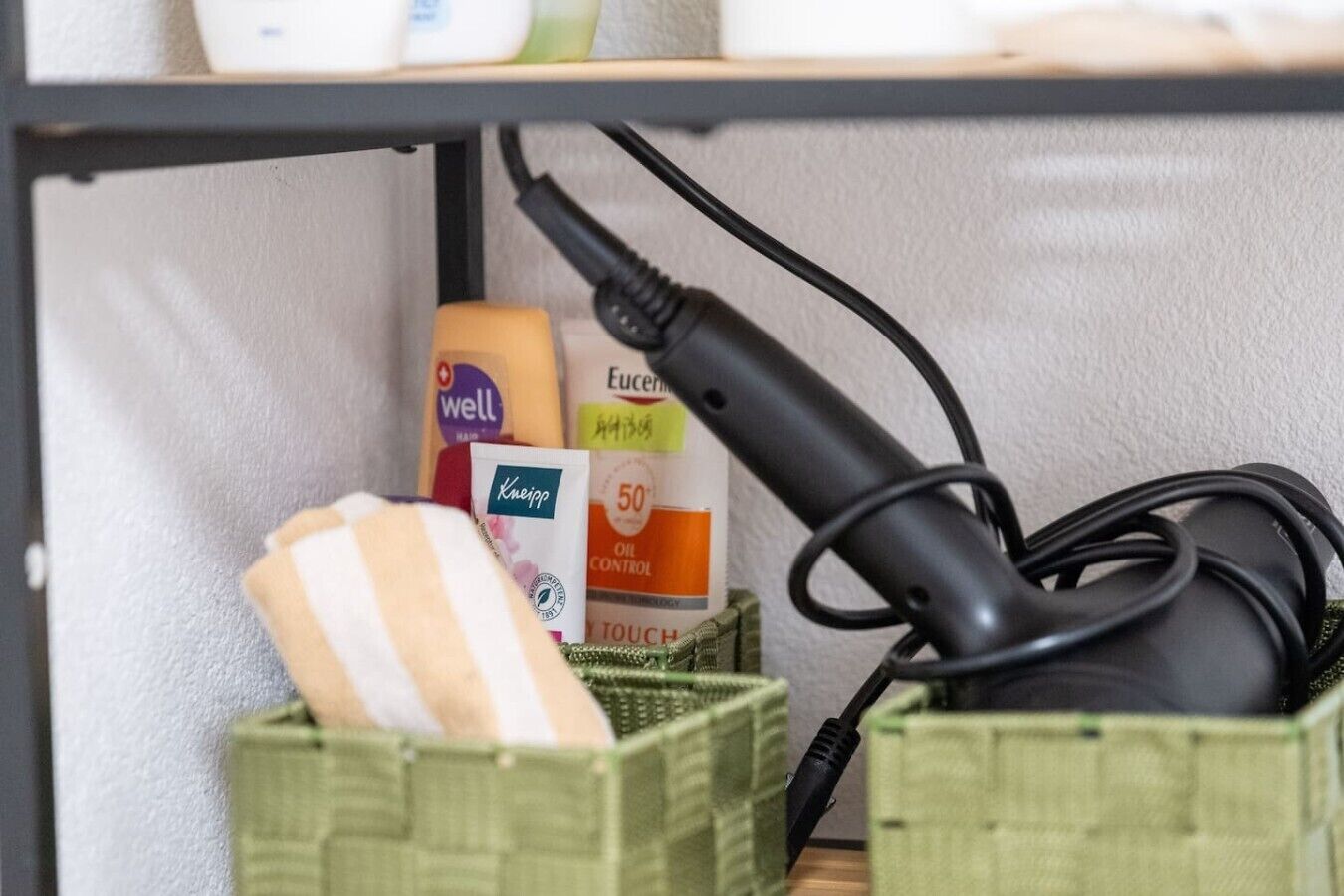 A shelf with various toiletries and a hairdryer.