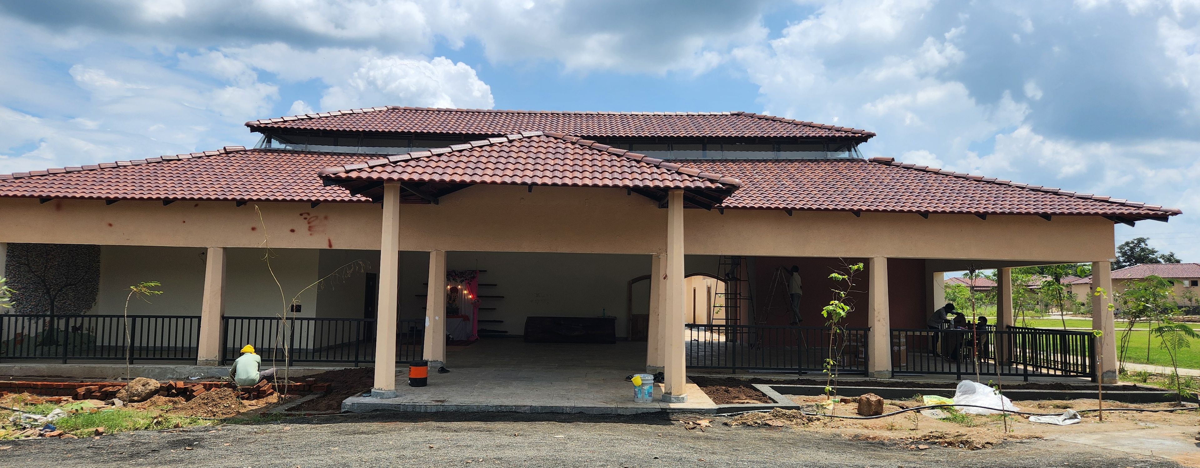 A two-story building with a tiled roof and a covered porch area.
