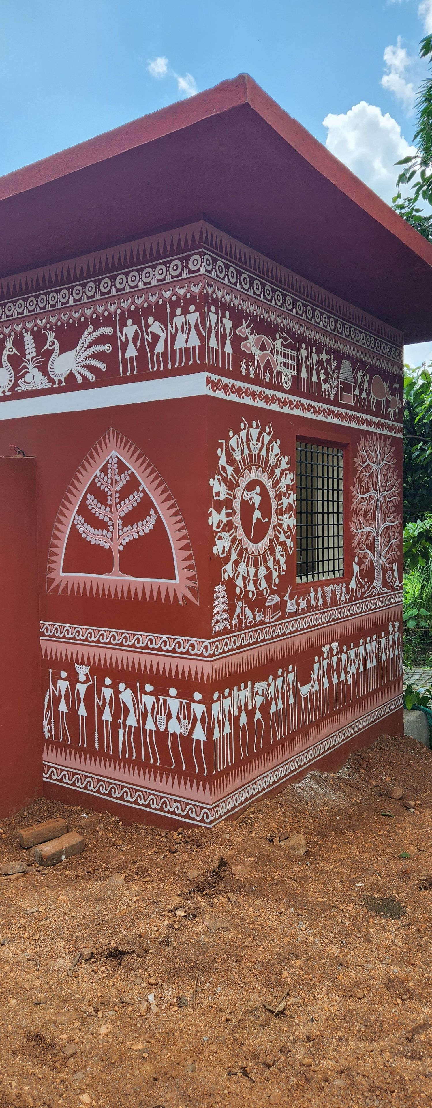 A building with traditional wall art depicting various figures and scenes.
